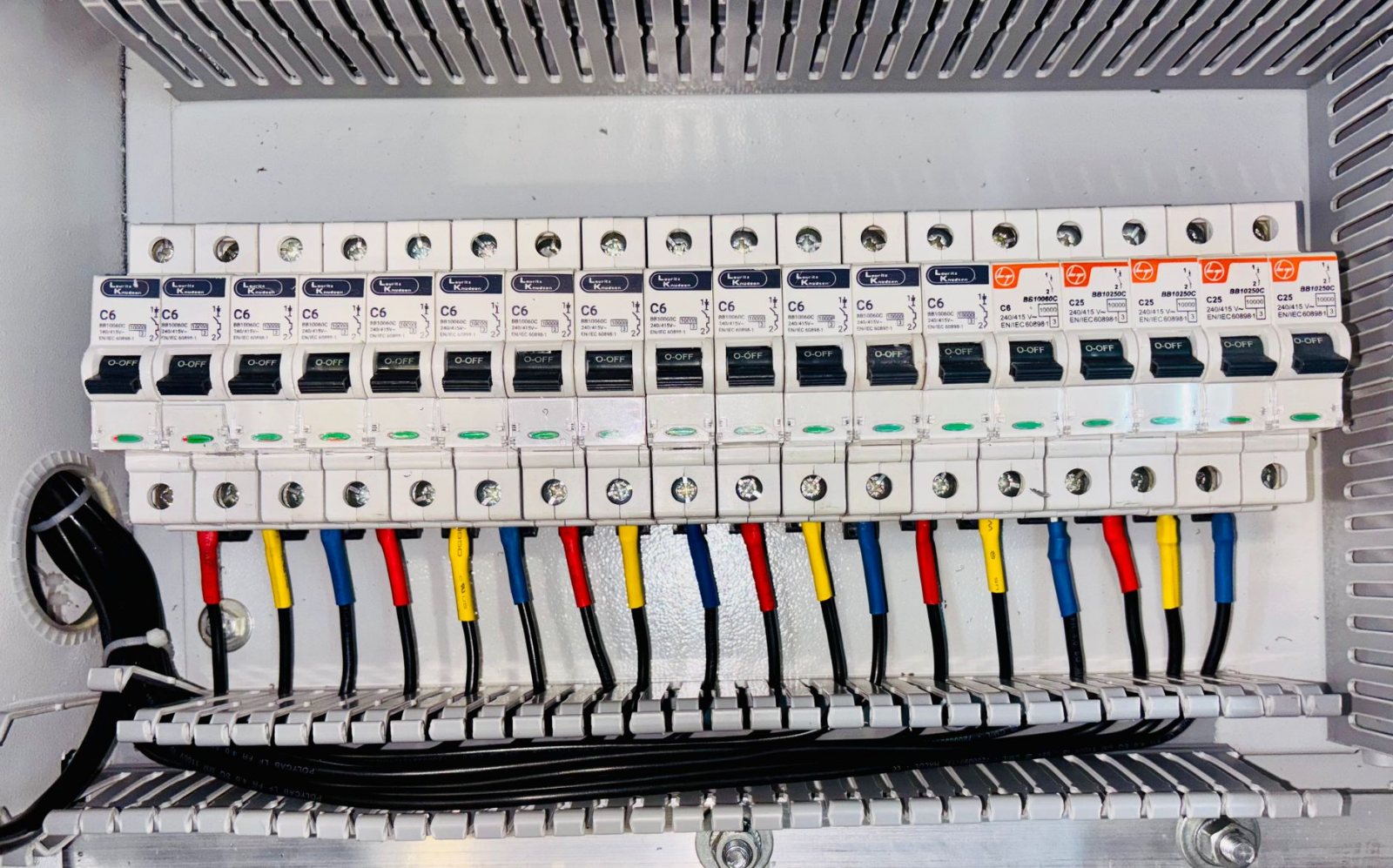 A finished load center fully wired, breakers labelled, conductors dressed and combed, deadfront ready to go back on